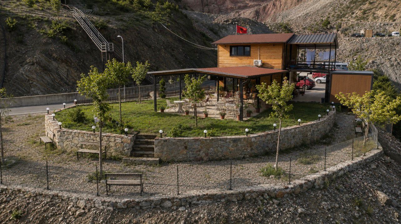 Panorama's stone-walled bar and café terrace beside the road to Koman