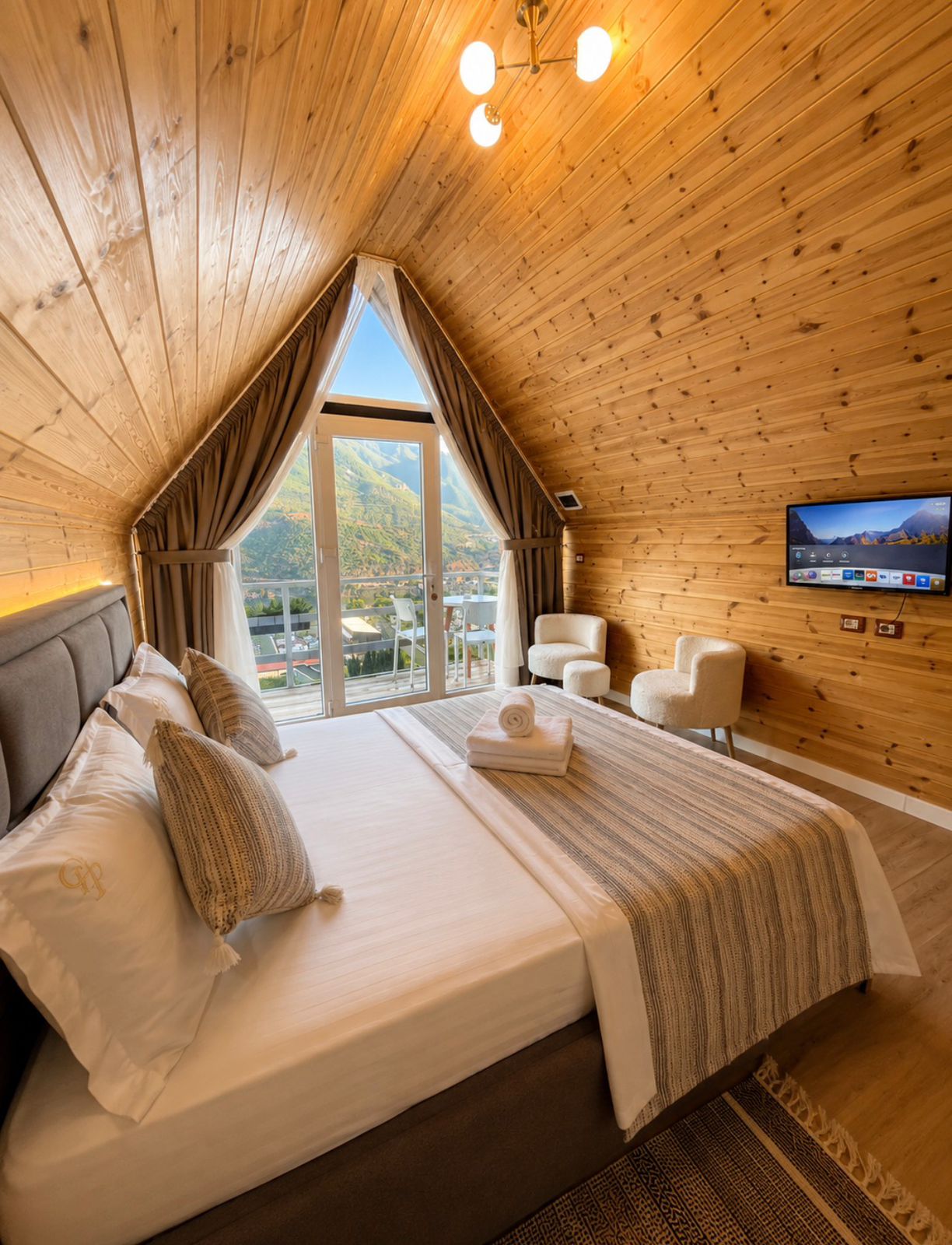 Interior of an A-frame couple cabin with wood ceiling and mountain view